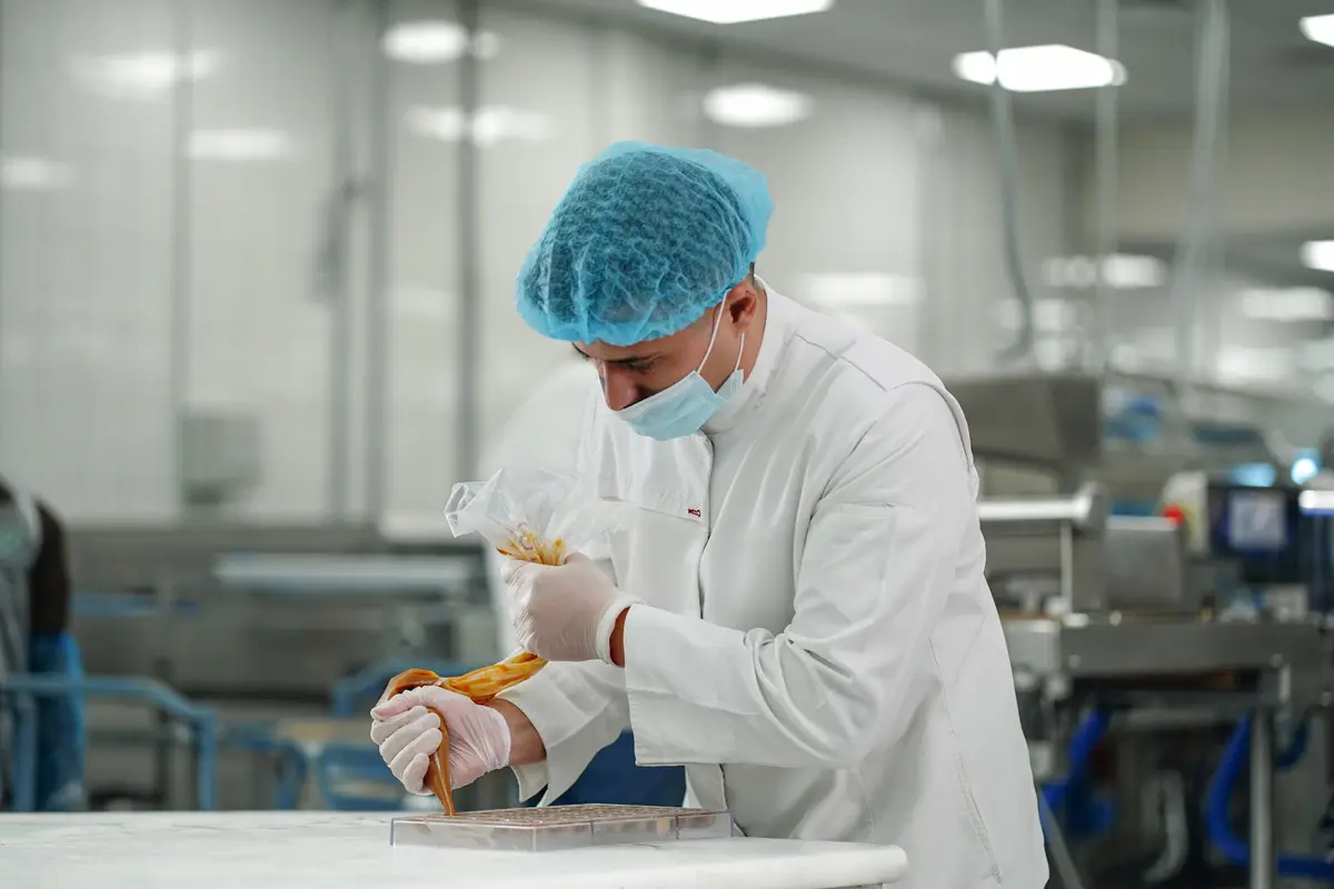 A chocolatier at the EDC factory finishing pieces by hand
