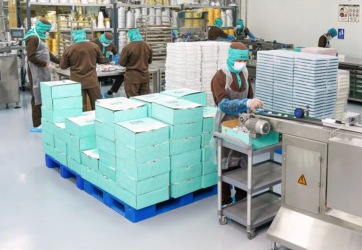 Boîtes cadeaux empilées sur une palette près de la ligne de conditionnement