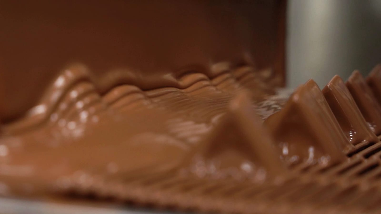 A curtain of chocolate coating pieces on the enrobing line at the EDC factory